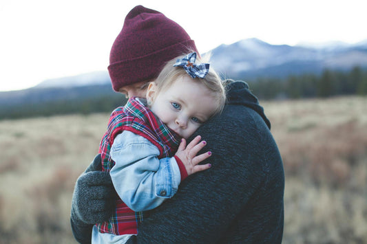 Père portant son enfant lors d'une randonnée en montagne
