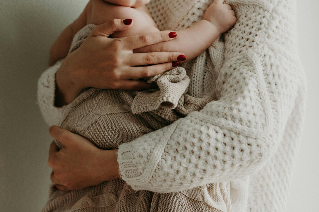 Mère portant bébé avec soutien ergonomique